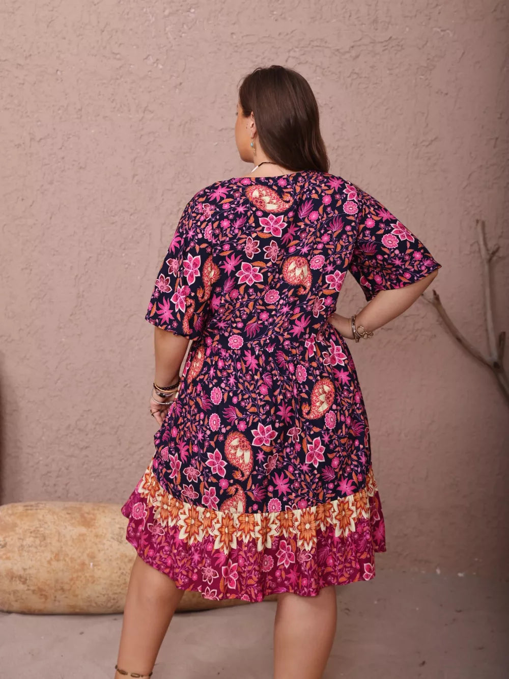 Plus-size navy floral flutter dress with ruched waist and tiered ruffle hem.