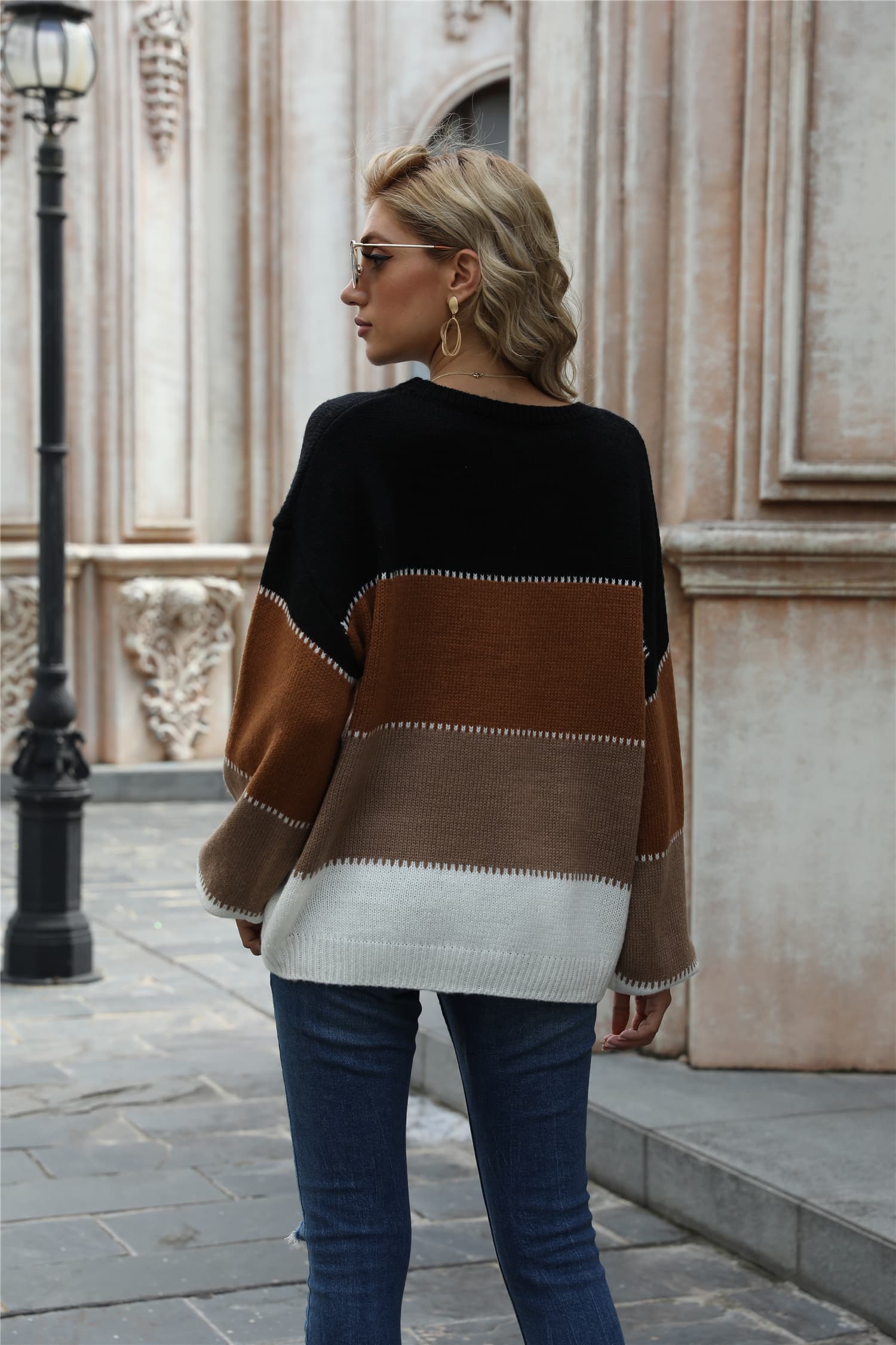 Crewneck knit sweater with black, brown, and white color blocking and acrylic material.