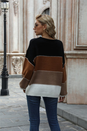 Crewneck knit sweater with black, brown, and white color blocking and acrylic material.