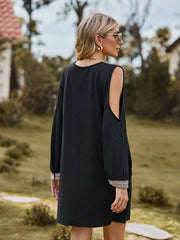 Black cold shoulder mini dress with lace trim cuffs and neckline detail.