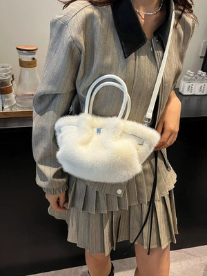 Plush crossbody bag in white with chic buckle and top handles.