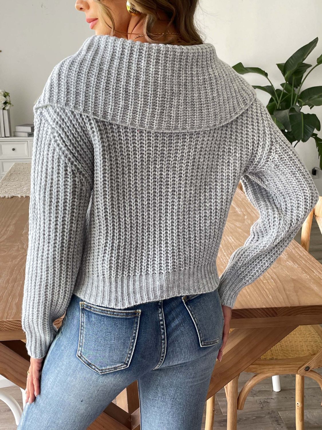 Gray ribbed knit sweater with a shawl collar and long sleeves.