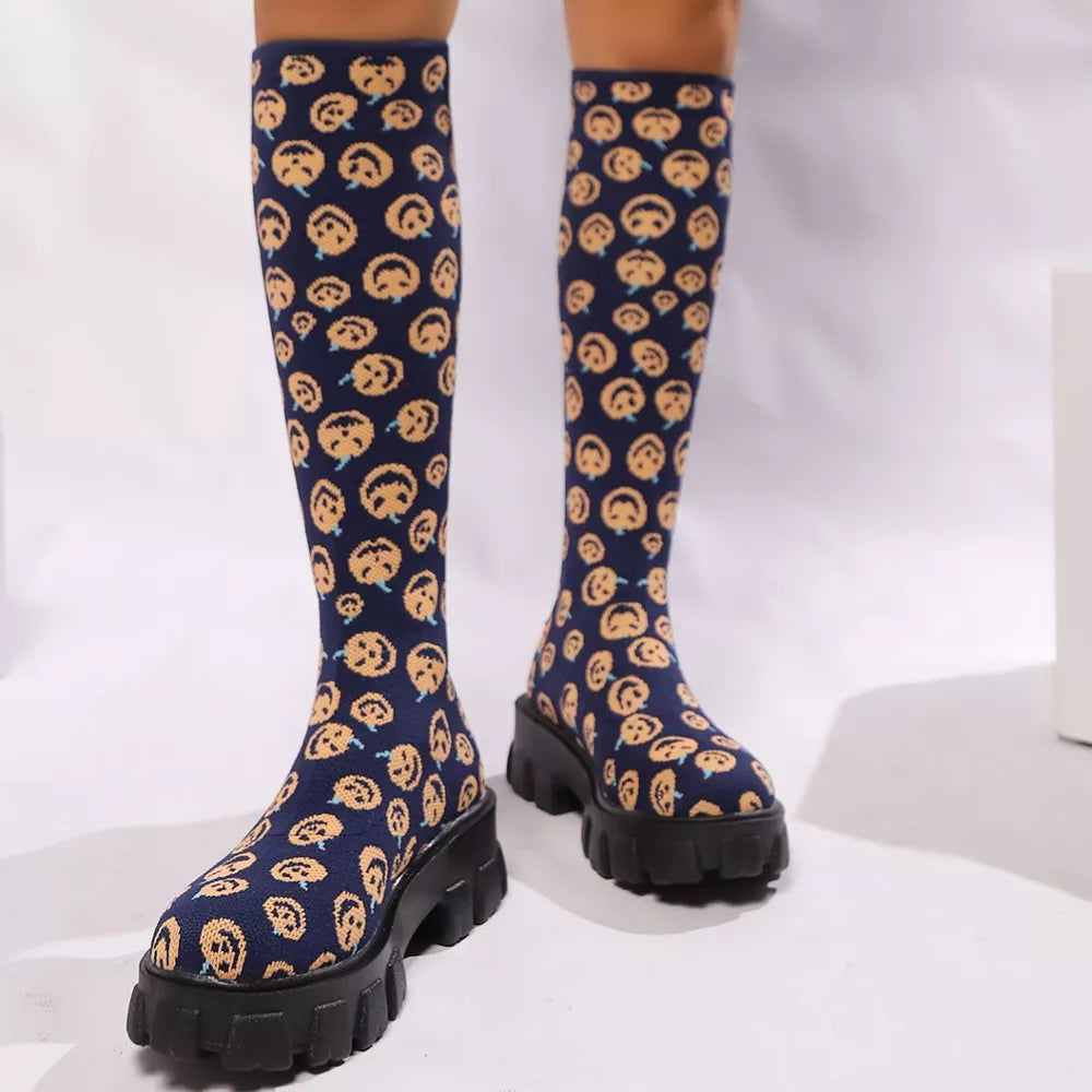 Navy blue knee-high boots with smiley face pattern and chunky platform sole.
