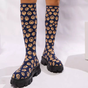 Navy blue knee-high boots with smiley face pattern and chunky platform sole.