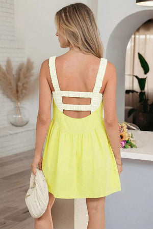Yellow gingham layered mini dress with back cutouts and ruffled straps.