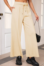 Palazzo joggers in Pastel Yellow with drawstring waist and center seam detail.