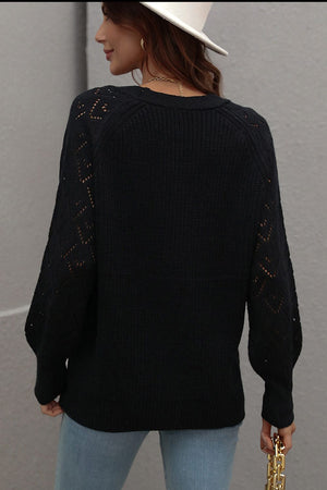Black diamond knit cardigan with openwork sleeves and crew neck.