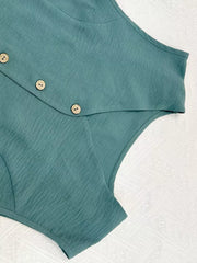 Turquoise cropped vest with button details and textured fabric.