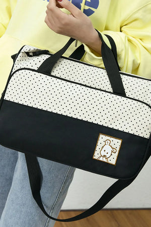 Black and white polka dot diaper bag with a cute embroidered dog patch and black trim.