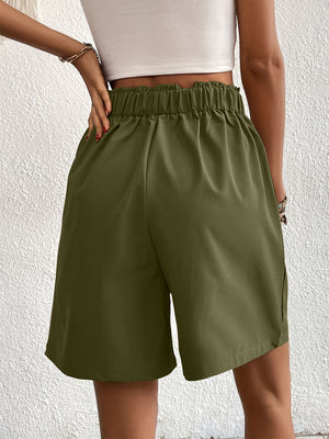 Pleated front bermuda shorts in dark green with a ruffled elastic waistband.