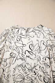 Ivory abstract scribble balloon sleeve blouse with crew neck and back keyhole closure.