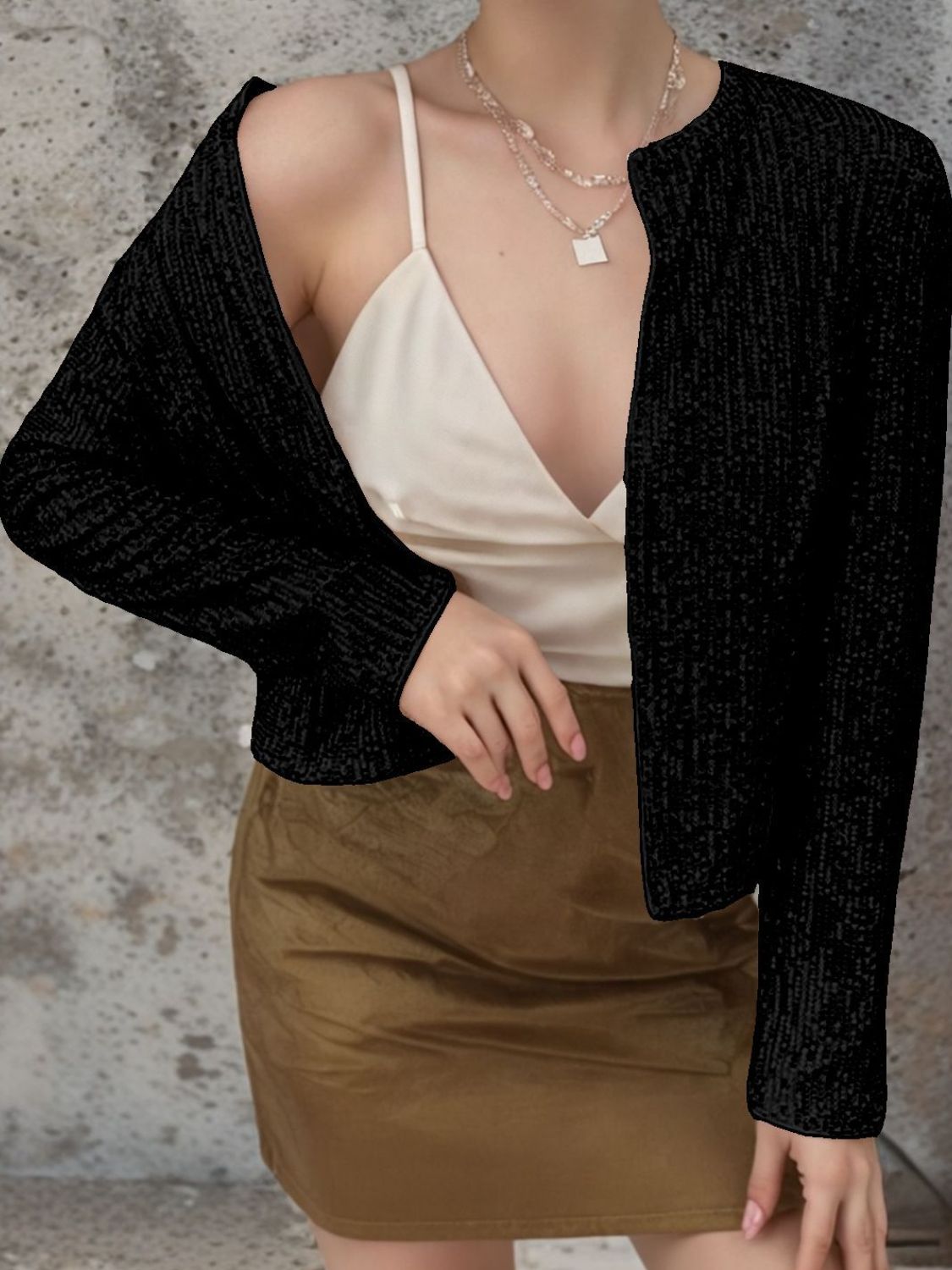 Black sequin bolero jacket with long sleeves and open front, worn over a white camisole.