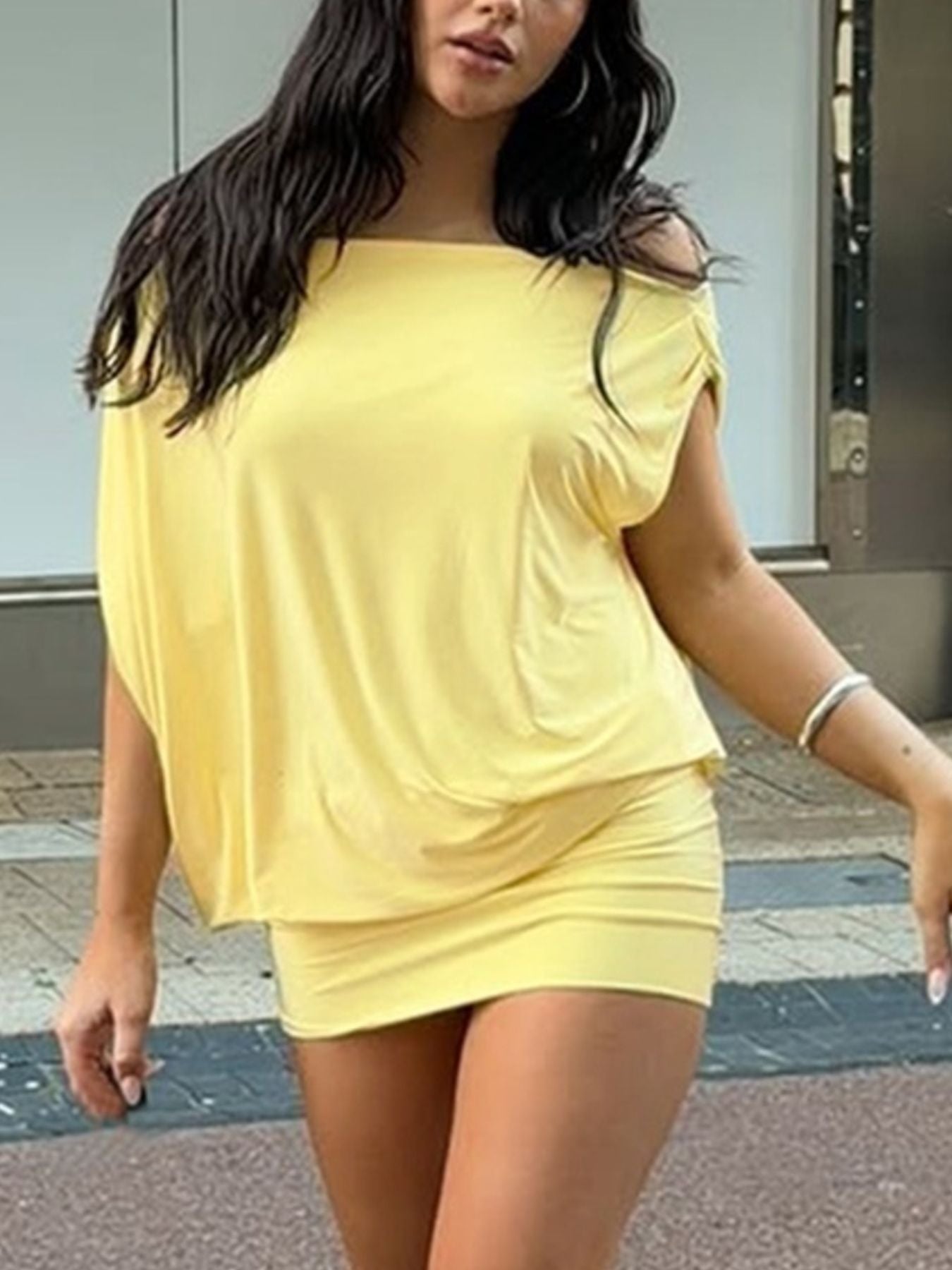 Yellow off-shoulder ruched mini dress with draped sleeves and a fitted skirt.
