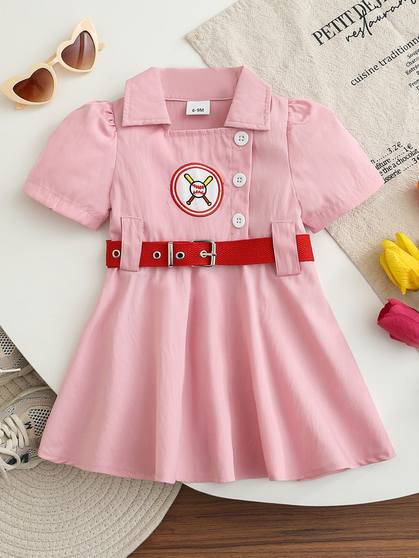 Pink cotton blend baseball dress for baby girls with embroidered logo and red belt.