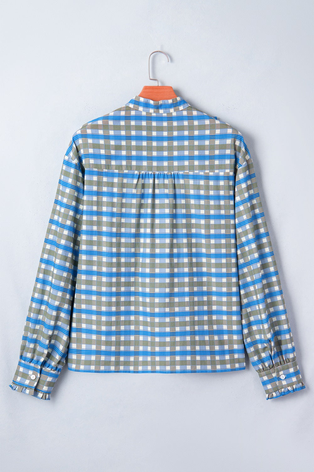 Blue plaid button-down blouse with frilled cuffs and button detail.