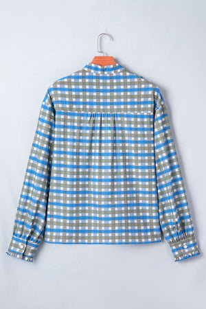 Blue plaid button-down blouse with frilled cuffs and button detail.