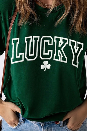 Dark green t-shirt with white LUCKY graphic and shamrock detail, rolled sleeves.
