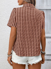 Rust red gingham button-up short-sleeve shirt with textured dots, styled with white denim shorts.
