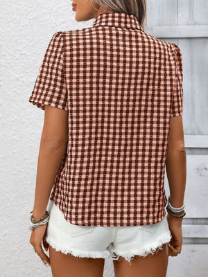 Rust red gingham button-up short-sleeve shirt with textured dots, styled with white denim shorts.