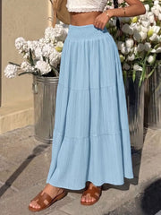 Blue smocked tiered maxi skirt with flowing elegance and textured fabric.