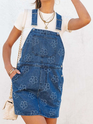 Embroidered denim pinafore dress in peacock blue with a floral pattern, featuring adjustable straps and a short skirt.