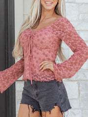 Pink floral lace blouse with tie-front detail and long bell sleeves.
