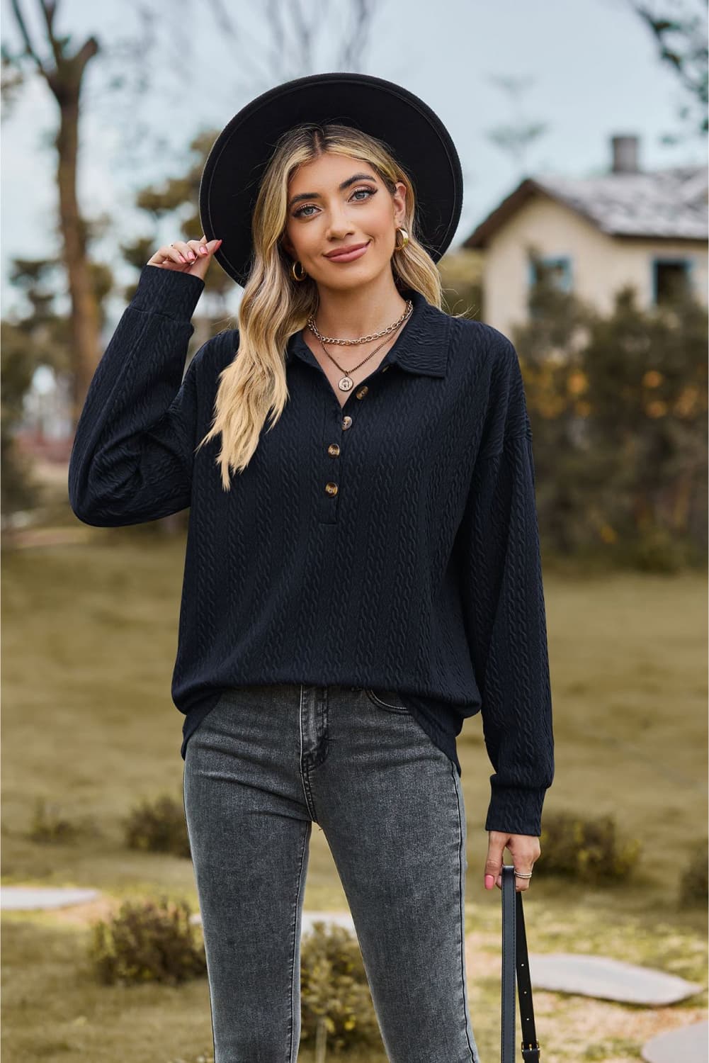 Textured knit polo shirt in dark blue with buttoned placket and long sleeves.