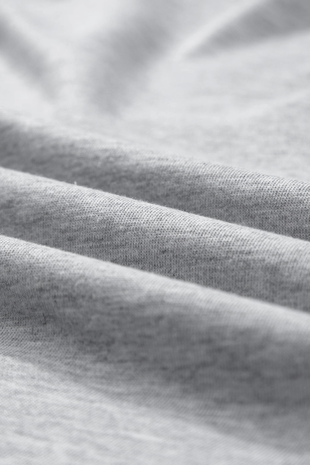 Gray sweatshirt fabric detail showing soft texture and folds.