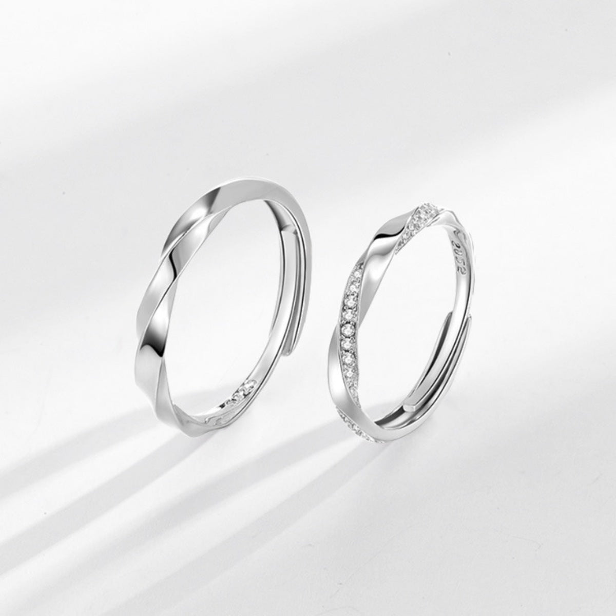 Adjustable sterling silver rings, one plain twisted band, one with pave zircon accents.