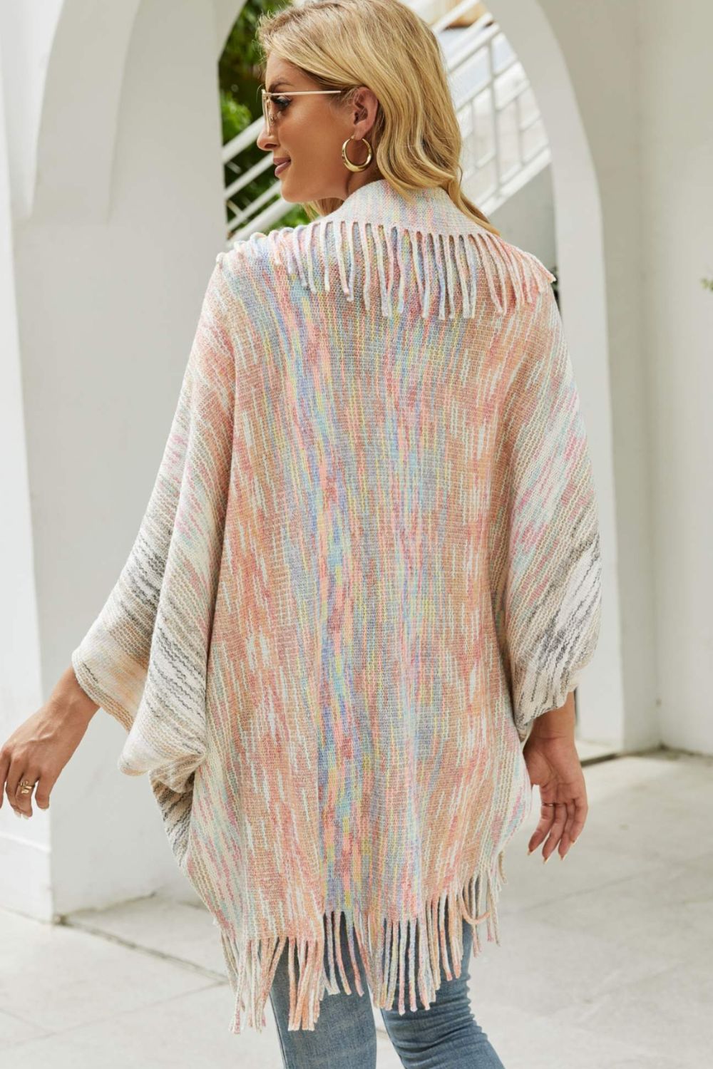 Textured stripe fringe cape with pastel multicolor yarn and fringe detail.