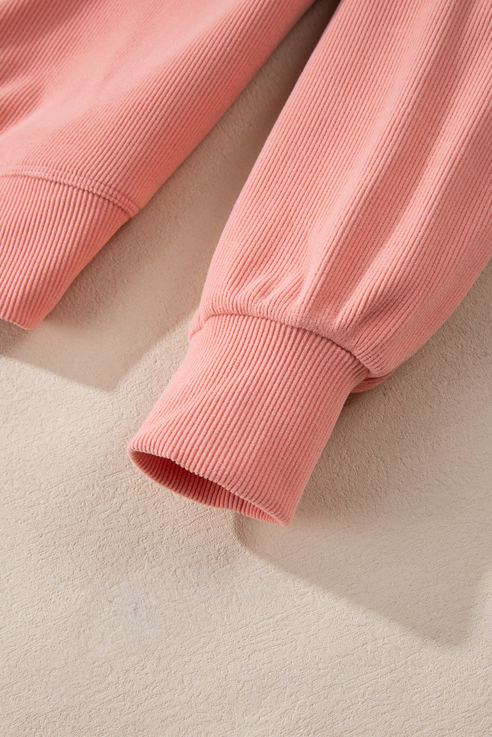 Pink plush corduroy loungewear set detail showing ribbed cuffs and hem.