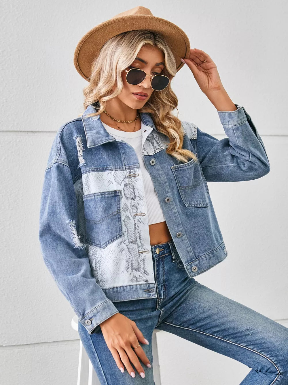 Denim trucker jacket with python pattern panels and distressed details.