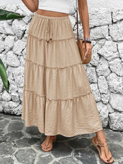 Tiered maxi skirt in tan with a drawstring waist and ruffled tiers.