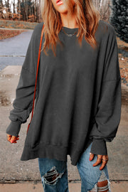 Oversized charcoal washed cotton sweatshirt with crew neck, long sleeves, and side slits.