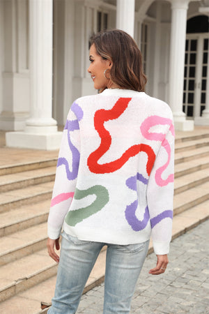 White crewneck sweater with abstract swirl pattern in red, pink, purple, and green.