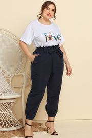 Paperbag waist lounge pants in navy with a belted tie waist and cuffed ankles.