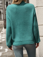 Textured mock-neck sweater in turquoise acrylic with a detailed knit pattern.
