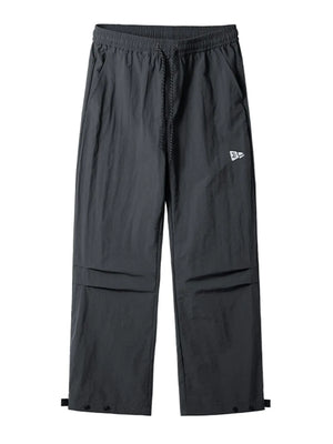 Dark gray utility joggers with relaxed fit, drawstring waist, cargo pockets, and adjustable ankle snaps.