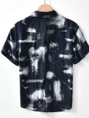 Men's black short sleeve polo with abstract print and button-down collar.