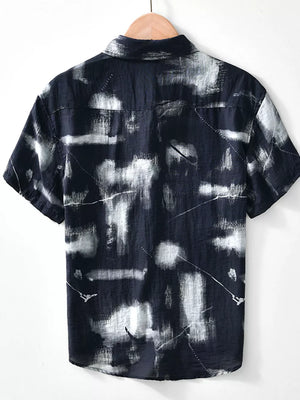 Men's black short sleeve polo with abstract print and button-down collar.