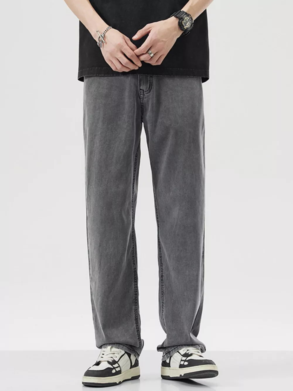 Relaxed fit wide-leg denim trousers in dark gray, styled casually.