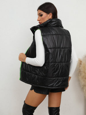 Black padded puffer vest with neon green zipper detail and high collar.