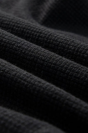 Black waffle knit jumpsuit detail showing texture
