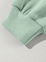 Sage green cotton joggers with ribbed cuffs and hem detail.