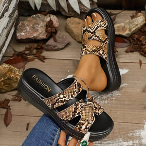 Distinctive two-strap platform sandals in snakeskin pattern with black soles.