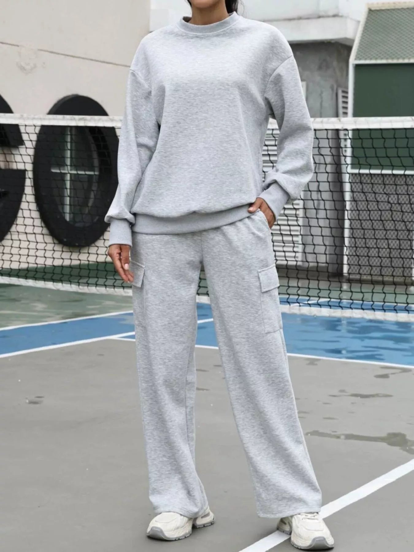 Light gray dropped shoulder sweatshirt and cargo pants set with crew neck and long sleeves.