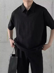 Black textured waffle knit polo shirt with short sleeves and button collar.