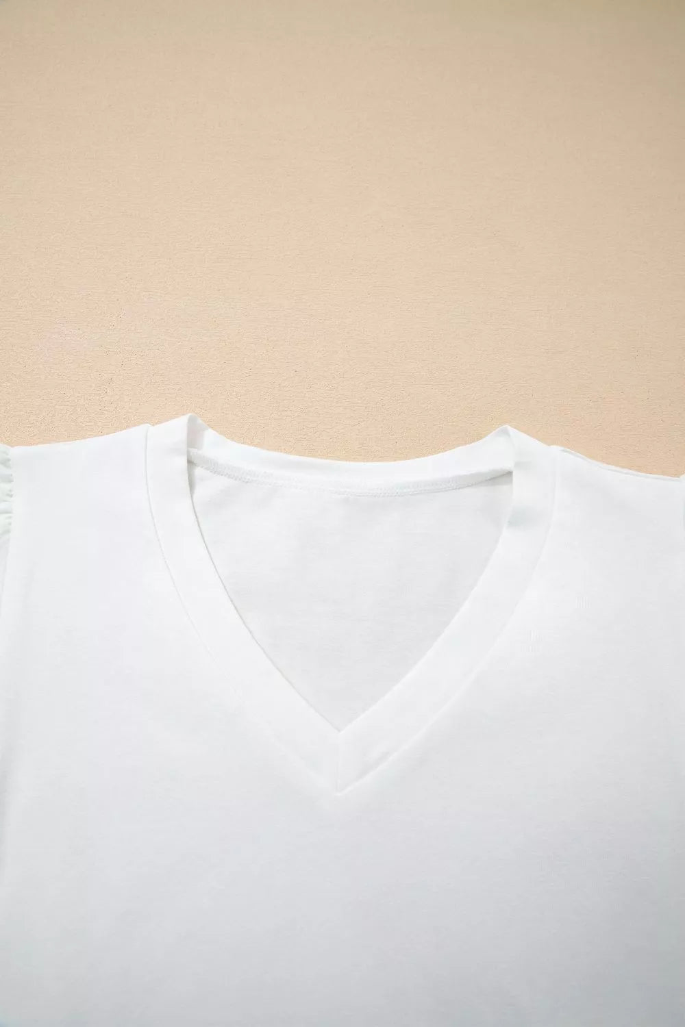 White cotton maternity t-shirt with V-neck and delicate eyelet flutter sleeves.