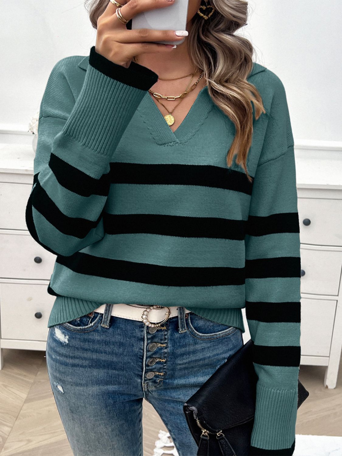 Turquoise and black striped knit polo sweater with a V-neck and collared neckline.