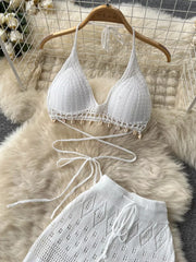 White crochet halter bikini top with shell trim and matching wide-leg pants.